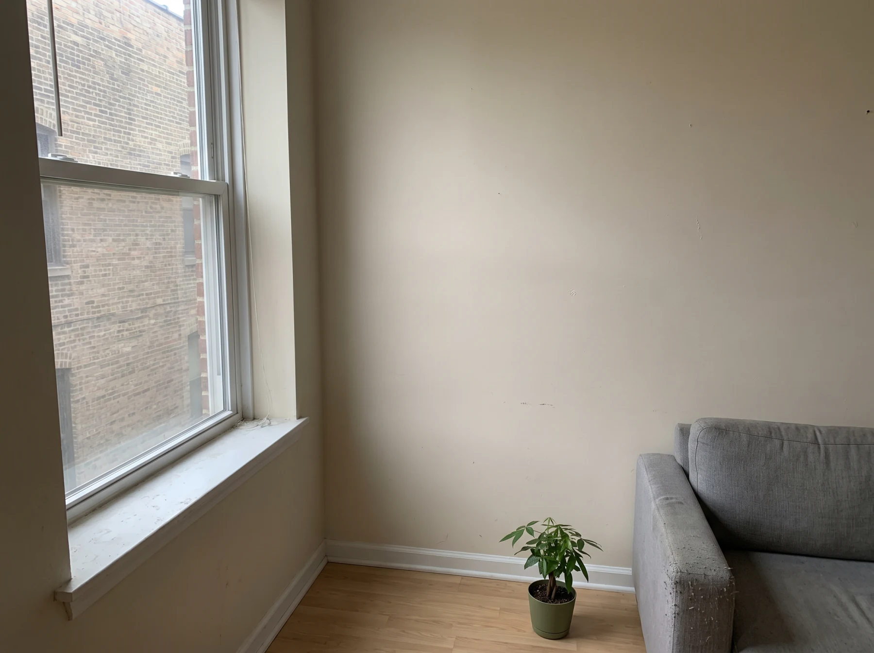 An empty apartment corner with a bare window
